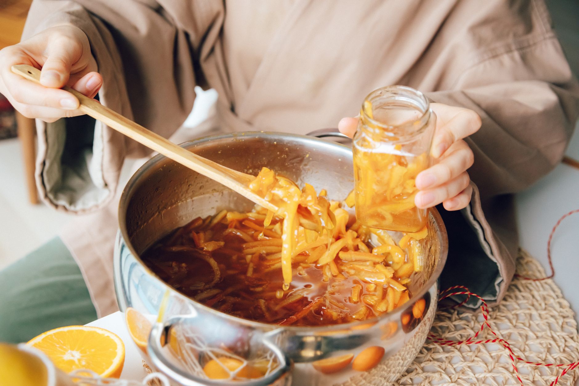A person twisting bright orange Cordyceps militaris mushrooms from a colonized brown rice jar