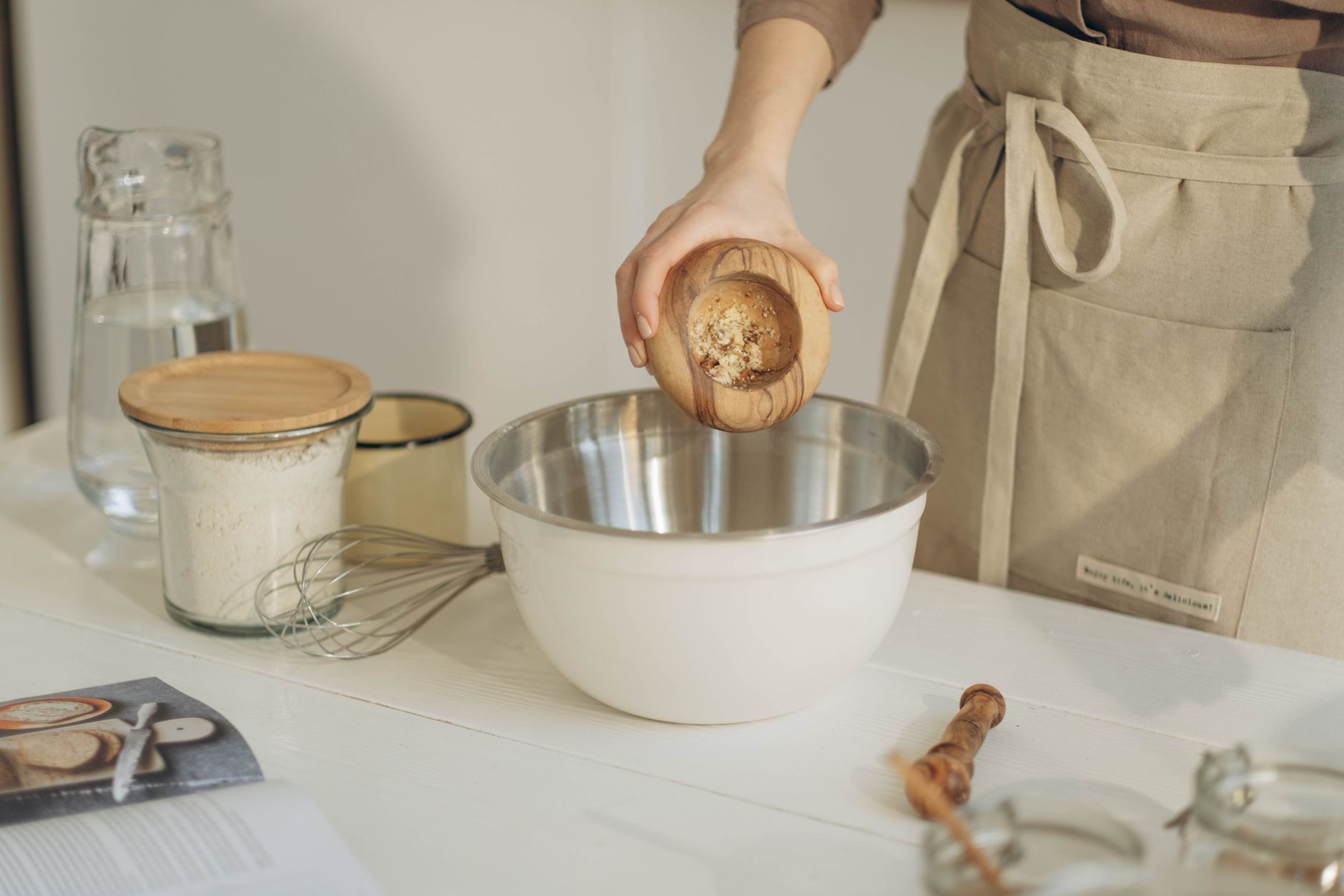 Hands mixing hardwood sawdust and bran for mushroom substrate in a large bowl