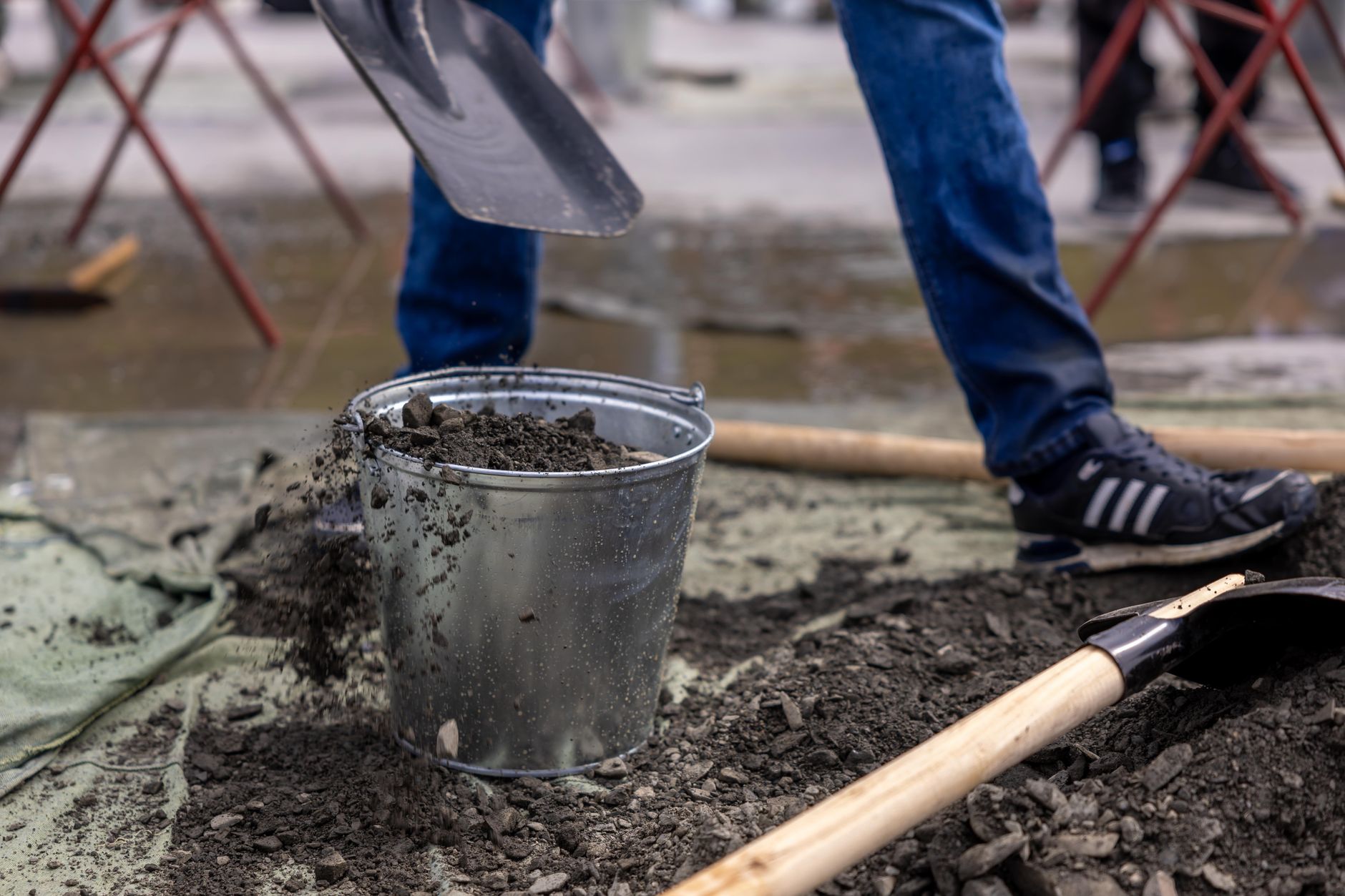 hands mixing supplemented sawdust substrate in a large bucket